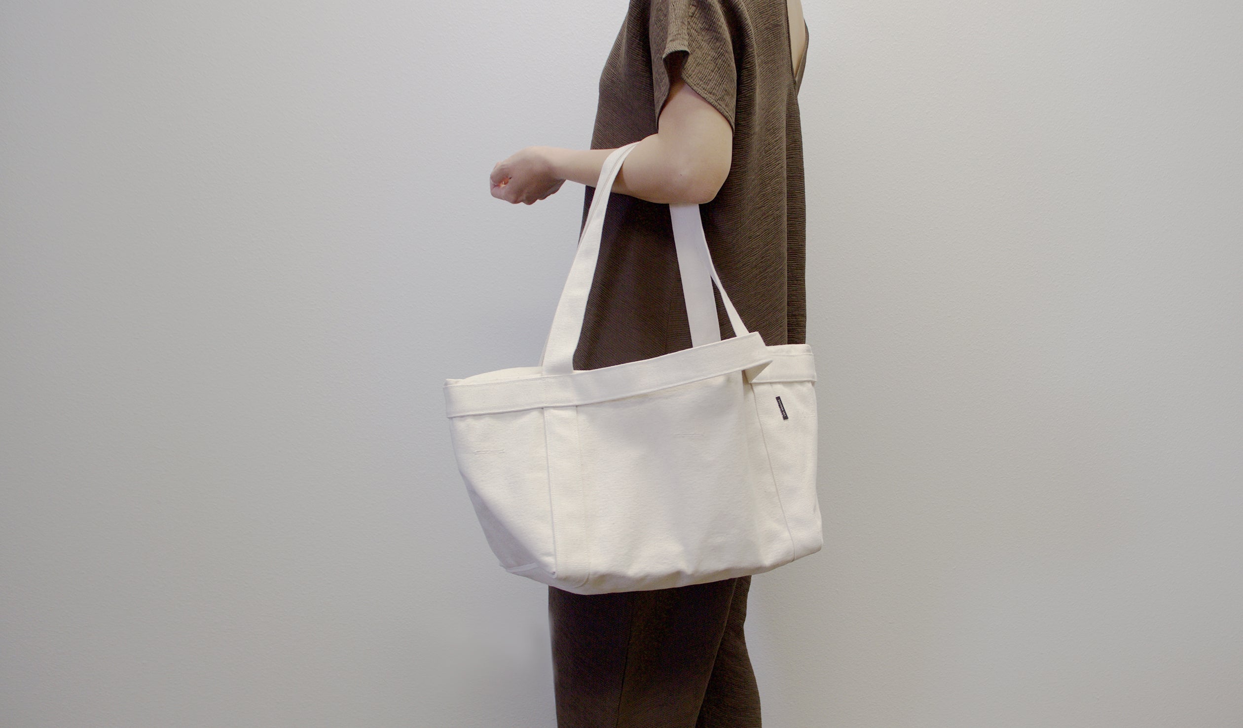 model holding grand day tote in natural color